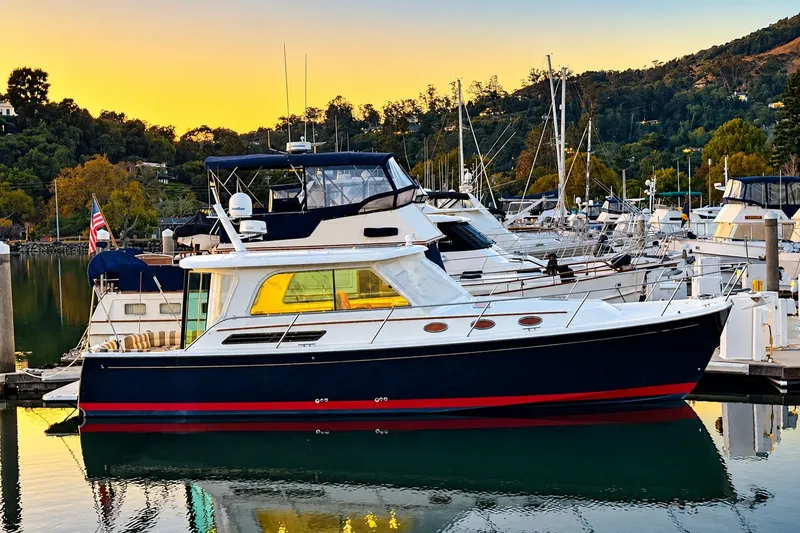 Slide: The Image of 2011 Back Cove 37 yacht docked at marina during sunset, surrounded by other boats. - 4