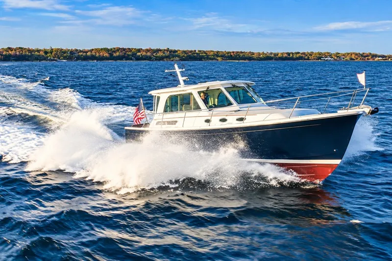 Slide: The Image of 2011 Back Cove 37 cruising on open water, creating a dynamic wake. - 34