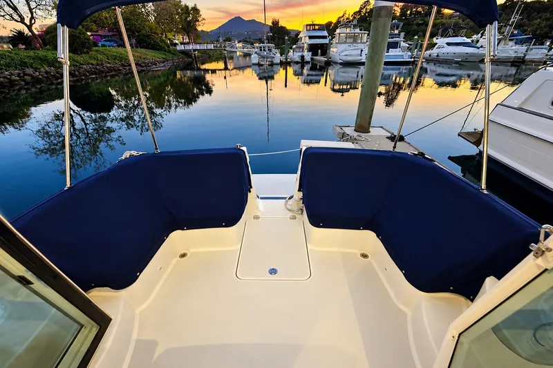 Slide: The Image of 2011 Back Cove 37 boat deck at sunset in a serene marina setting. - 9