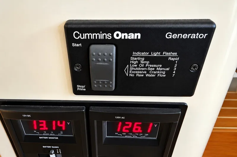 Slide: The Image of Cummins Onan generator control panel on 2011 Back Cove 37 boat, showing voltage readings. - 19