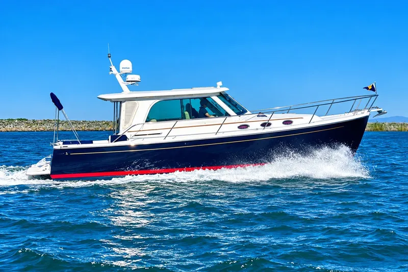 Slide: The Image of 2011 Back Cove 37 yacht cruising on open water under clear blue skies. - 3