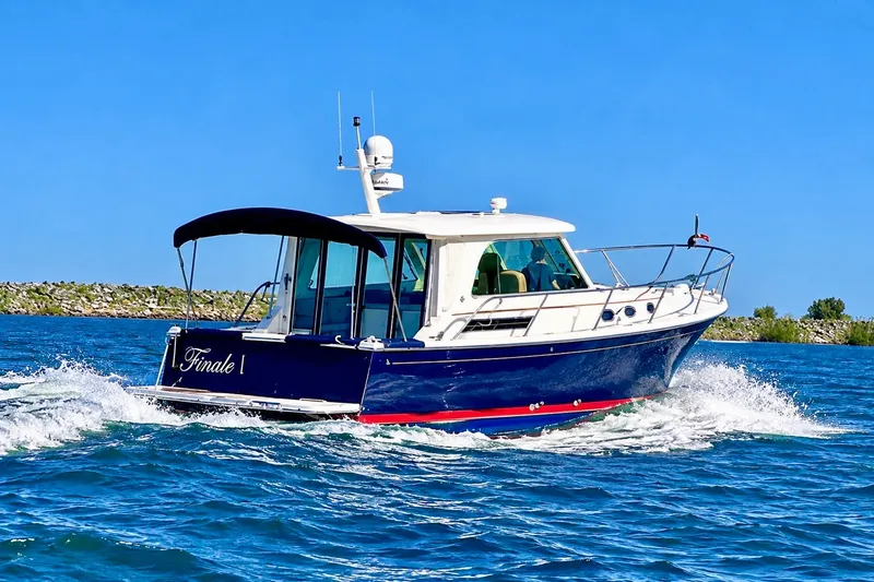 Slide: The Image of 2011 Back Cove 37 boat cruising on blue water under clear sky. - 2