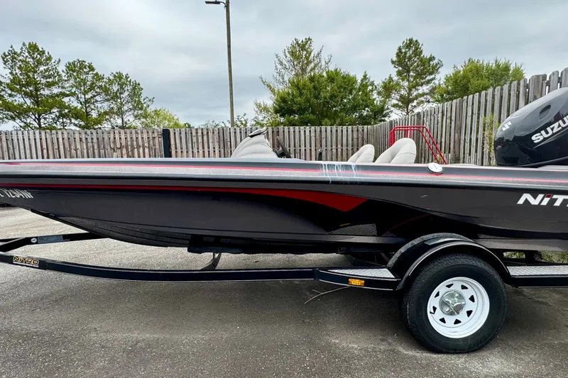 Slide: The Image of 2006 Nitro 482 SC boat on trailer, black with red accents, parked outdoors. - 1