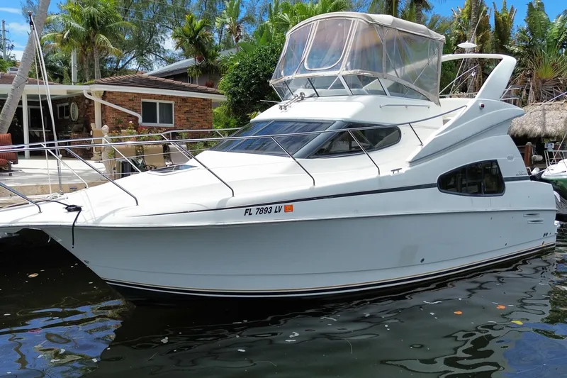 Slide: The Image of 2002 Silverton 330 Sport Bridge yacht docked near a tropical waterfront home. - 63