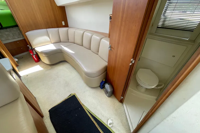 Slide: The Image of Interior of 2002 Silverton 330 Sport Bridge with beige seating and compact bathroom. - 25