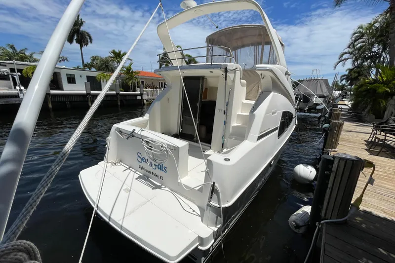 Slide: The Image of 2002 Silverton 330 Sport Bridge docked, featuring sleek design and spacious deck. - 16