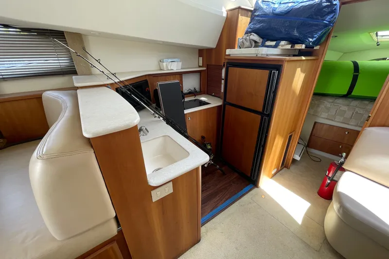 Slide: The Image of Interior of a 2002 Silverton 330 Sport Bridge yacht with kitchenette and seating area. - 30