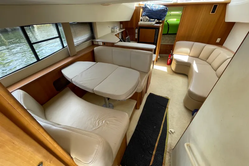 Slide: The Image of Interior of 2002 Silverton 330 Sport Bridge yacht with beige seating and dining area. - 23