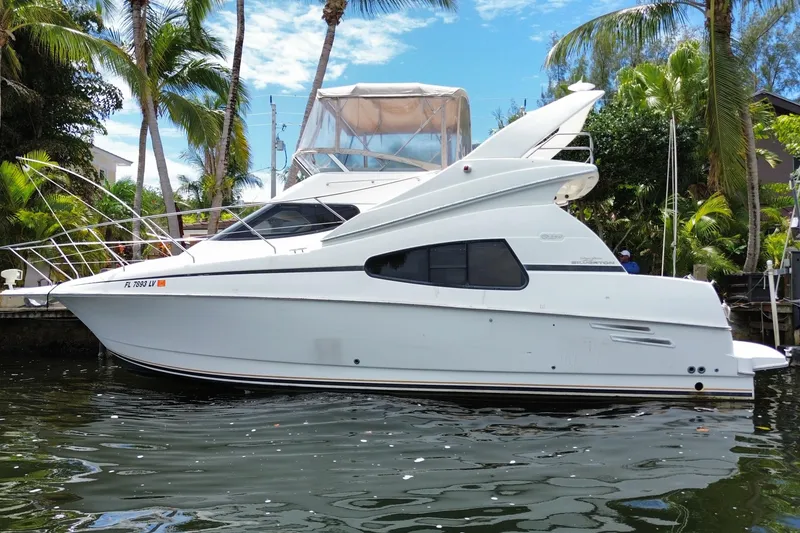 Slide: The Image of 2002 Silverton 330 Sport Bridge yacht docked near palm trees. - 60