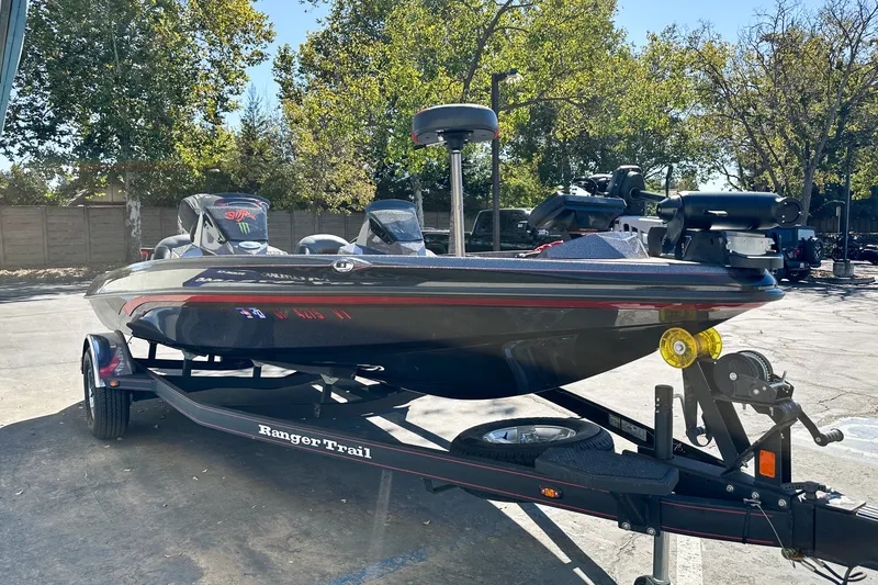 The Image of 2025 Ranger Z185 boat on trailer, parked outdoors with trees in background. - 0