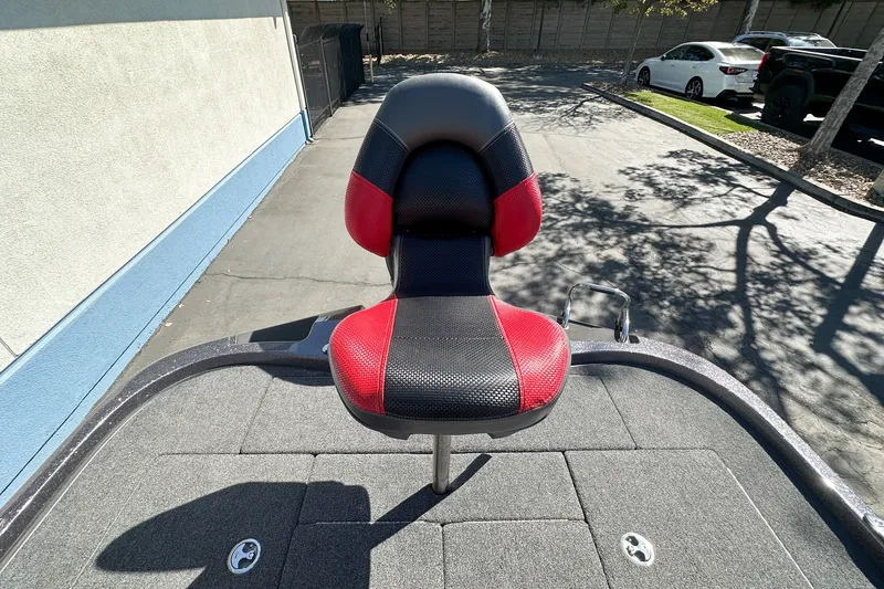 Slide: The Image of Red and black seat on 2025 Ranger Z185 boat deck, parked outdoors. - 23