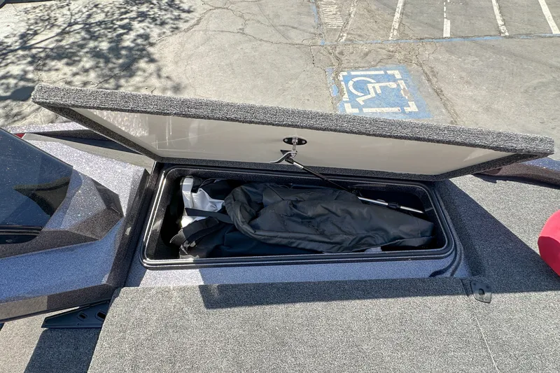 Slide: The Image of Open storage compartment on 2025 Ranger Z185 boat, showing interior contents. - 16