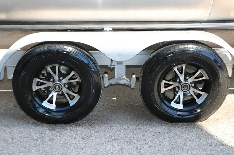 Slide: The Image of Close-up of two shiny black tires with silver rims on a trailer. - 24