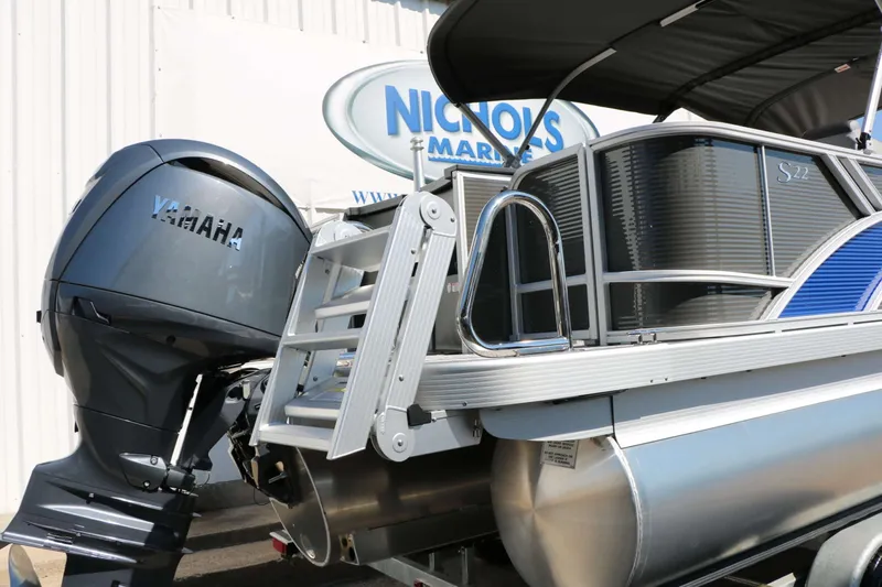 Slide: The Image of A 2027 Bennington 22 SFC Tri Toon with a Yamaha outboard motor and blue accents. - 22