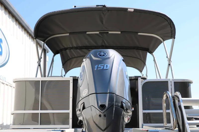 Slide: The Image of A 2027 Bennington 22 SFC Tri Toon with a large outboard motor and a sunshade. - 18