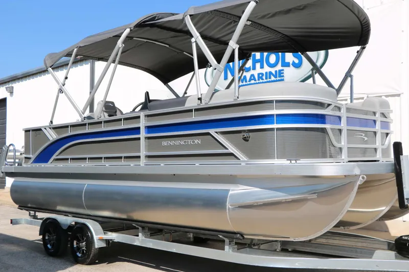 The Image of Bennington 22 SFC Tri Toon 2027 with blue stripe, on a trailer, featuring a sunshade. - 0