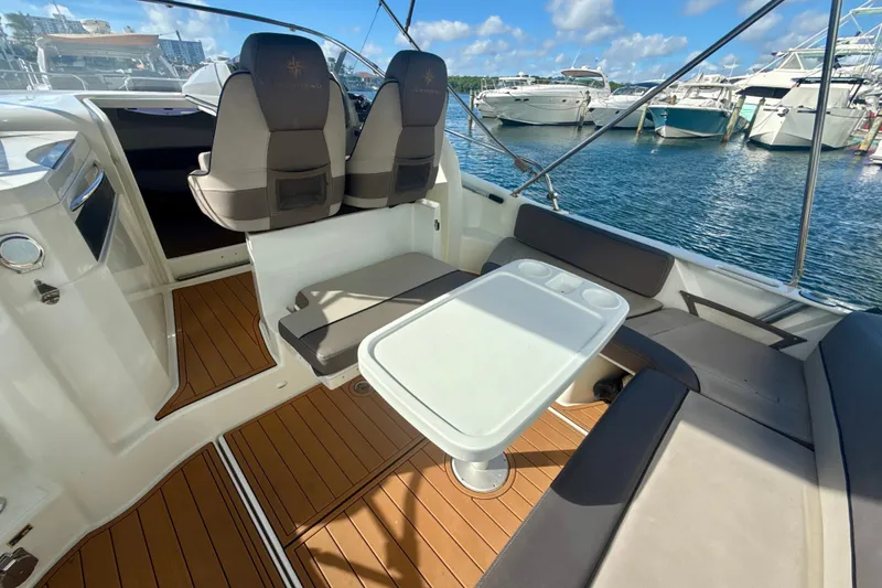 Slide: The Image of 2018 Jeanneau Cap Camarat 8.5 WA boat interior with seating and table, docked at marina. - 5