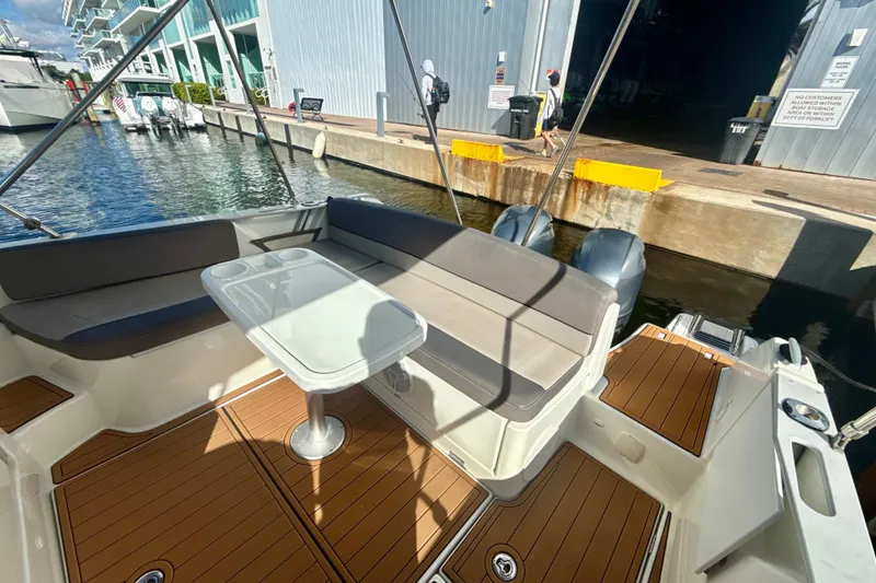 Slide: The Image of 2018 Jeanneau Cap Camarat 8.5 WA boat with seating area and table, docked at marina. - 6