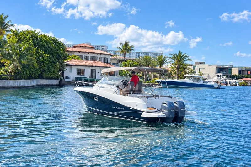 Slide: The Image of 2018 Jeanneau Cap Camarat 8.5 WA cruising on a sunny waterfront with palm trees. - 3