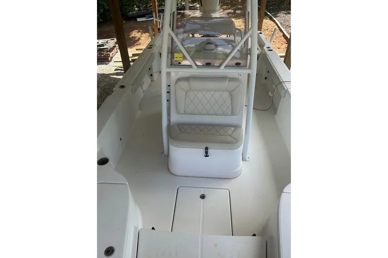 Slide: The Image of 2020 Blue Wave 2600 PureBay boat interior with seating and console, under shelter. - 9