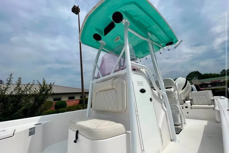 Slide: The Image of 2020 Blue Wave 2600 PureBay boat with teal canopy and white seating, outdoors. - 6