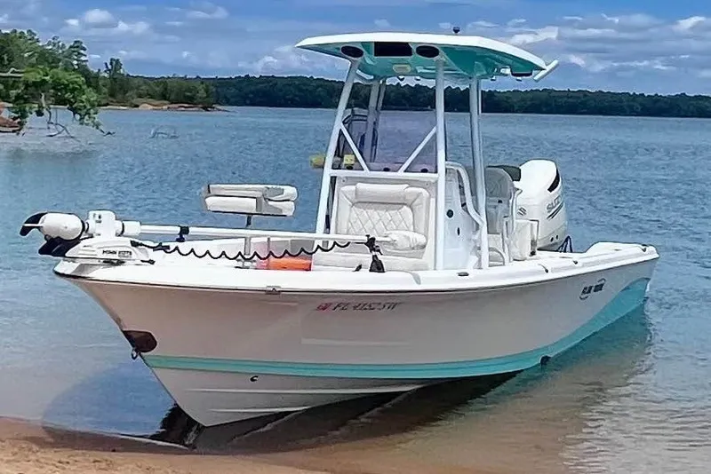 The Image of 2020 Blue Wave 2600 PureBay boat docked on a serene lake shore. - 1