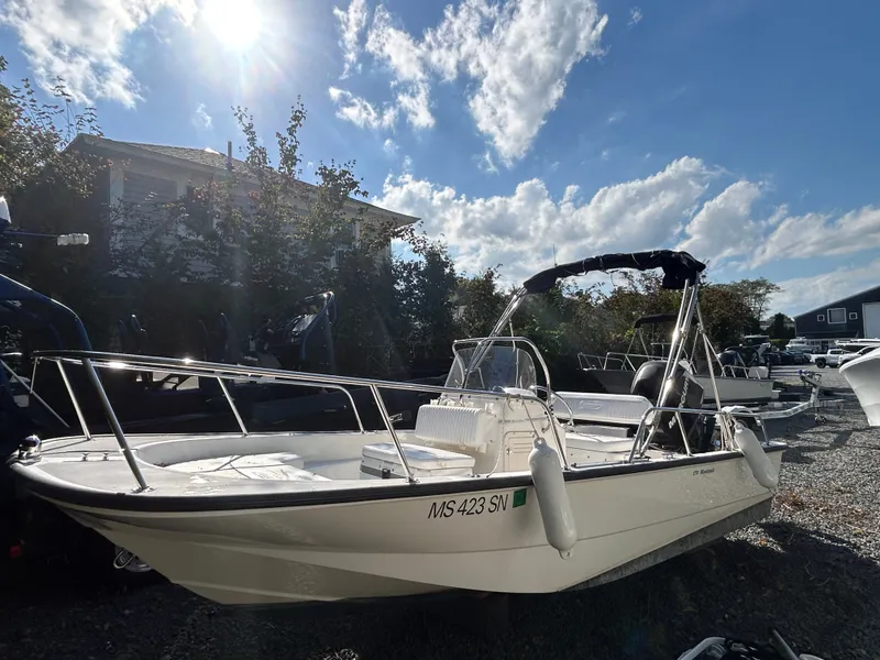 Slide: The Image of A 2007 Boston Whaler 17 Montauk sits on a gravel lot. The sky is sunny with clouds. - 1