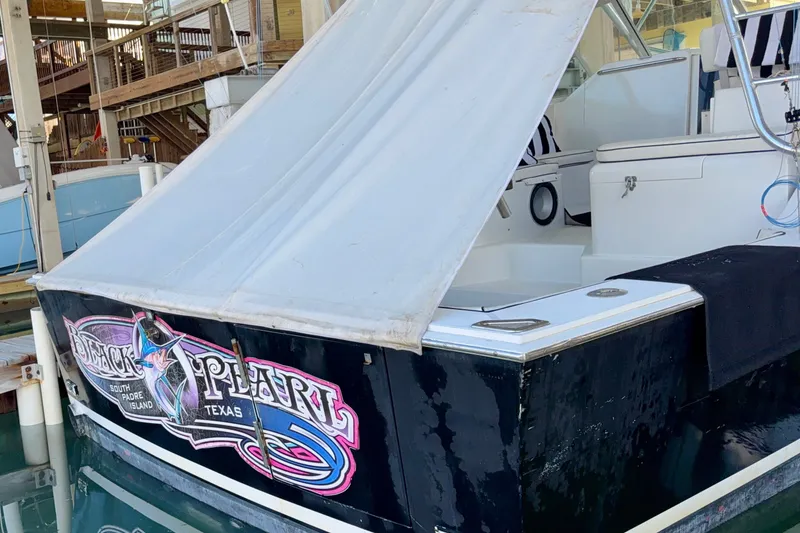 Slide: The Image of 1995 Cabo 35 Express boat docked, featuring "Black Pearl" signage, South Padre Island, Texas. - 4