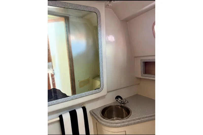 Slide: The Image of Interior of 1995 Cabo 35 Express boat featuring a compact bathroom sink area. - 27