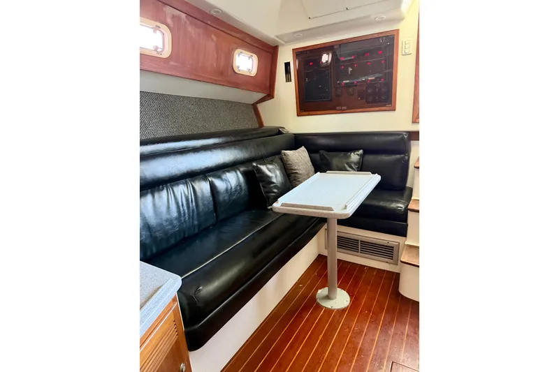 Slide: The Image of Interior of 1995 Cabo 35 Express boat with black leather seating and wooden flooring. - 22