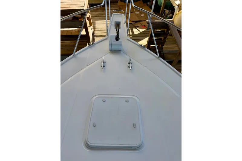 Slide: The Image of Bow view of 1995 Cabo 35 Express boat with deck hatch and railing. - 10