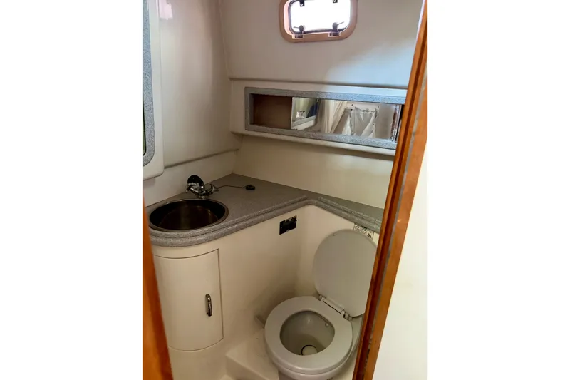 Slide: The Image of 1995 Cabo 35 Express boat bathroom with sink, toilet, and mirror. - 45