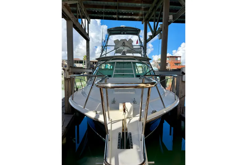 Slide: The Image of 1995 Cabo 35 Express yacht docked under shelter with clear blue sky. - 5