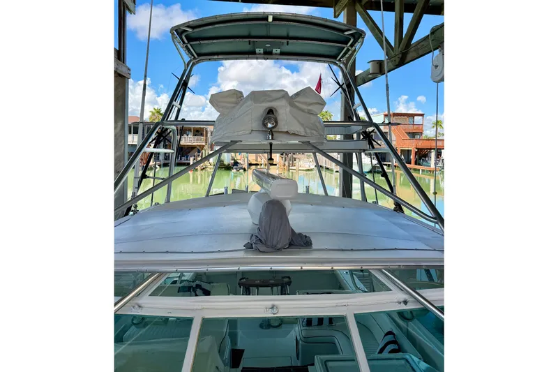 Slide: The Image of 1995 Cabo 35 Express boat docked, showcasing upper deck and marina background. - 7