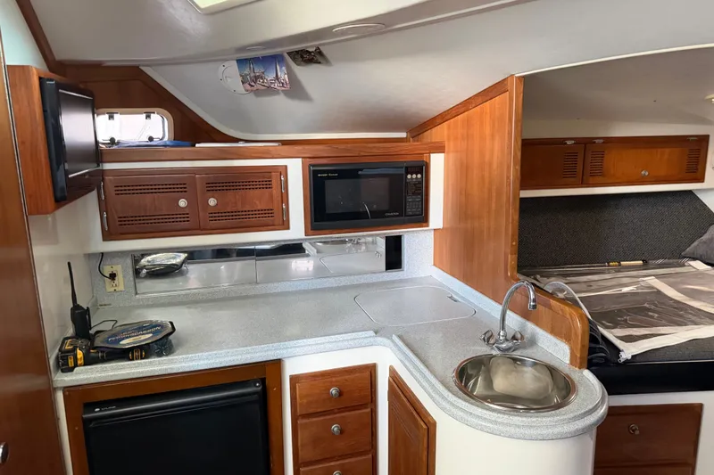 Slide: The Image of Interior of a 1995 Cabo 35 Express boat featuring a compact kitchen area. - 21