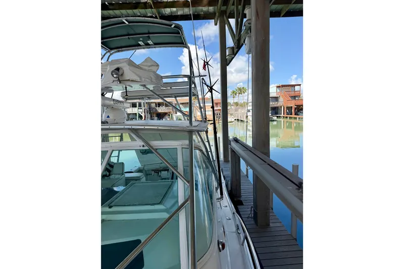 Slide: The Image of 1995 Cabo 35 Express boat docked in a marina under a clear blue sky. - 8