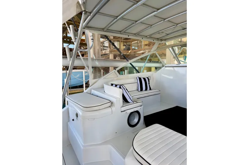 Slide: The Image of 1995 Cabo 35 Express boat interior with white seating and striped cushions. - 14