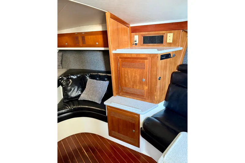 Slide: The Image of Interior of 1995 Cabo 35 Express boat with wood cabinetry and black leather seating. - 26