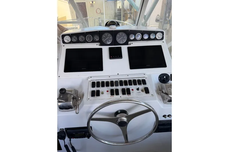 Slide: The Image of Helm of 1995 Cabo 35 Express boat with gauges, controls, and steering wheel. - 16