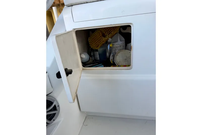 Slide: The Image of Open storage compartment on 1995 Cabo 35 Express boat with cleaning supplies. - 41