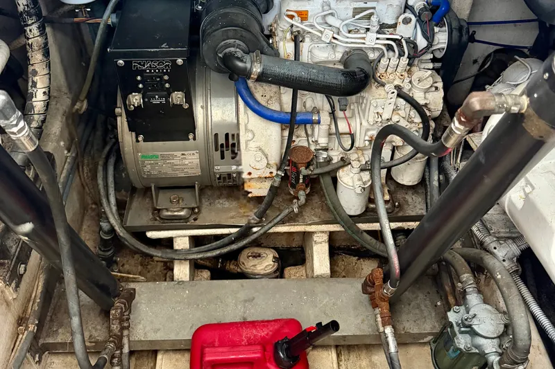 Slide: The Image of Engine compartment of a 1995 Cabo 35 Express boat, showcasing mechanical components and wiring. - 35