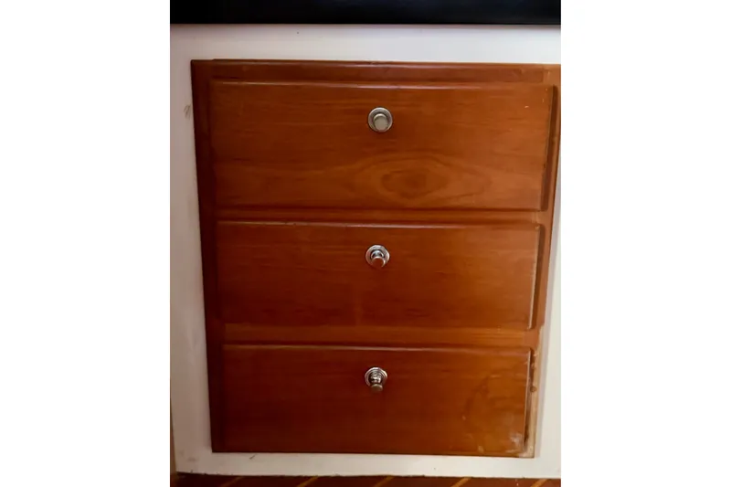 Slide: The Image of Wooden cabinet drawers with metal knobs on a 1995 Cabo 35 Express boat. - 25