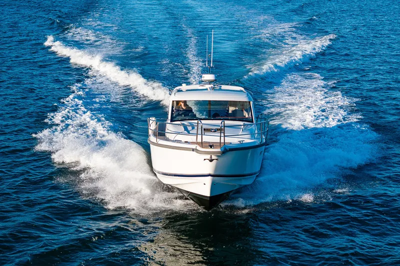 Slide: The Image of 2024 Nimbus 365 Coupe cruising on open water, creating a dynamic wake. - 30