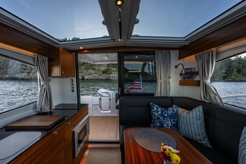 Slide: The Image of Interior of 2024 Nimbus 365 Coupe yacht with elegant wood finish and scenic water view. - 8