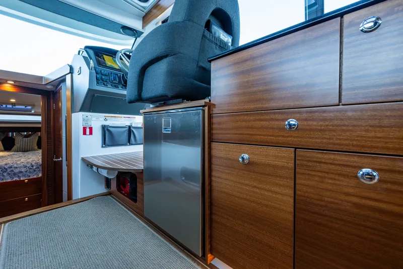 Slide: The Image of Interior of 2024 Nimbus 365 Coupe featuring wood cabinetry and modern helm station. - 10