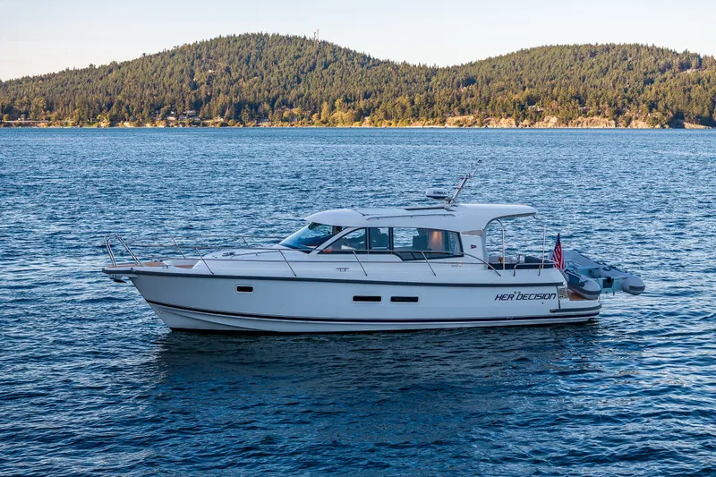 Slide: The Image of 2024 Nimbus 365 Coupe yacht on serene water with forested hills in the background. - 39