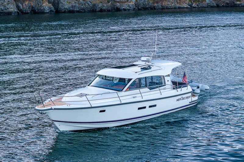 Slide: The Image of 2024 Nimbus 365 Coupe cruising on serene waters near rocky shoreline. - 42