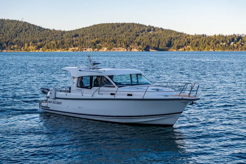 Slide: The Image of 2024 Nimbus 365 Coupe cruising on a serene lake with forested hills in the background. - 36