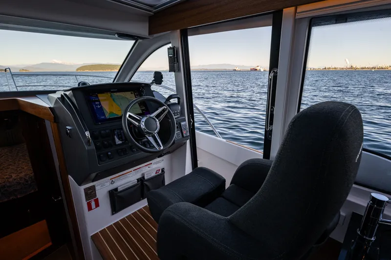 Slide: The Image of Interior view of 2024 Nimbus 365 Coupe boat cockpit with ocean backdrop. - 14