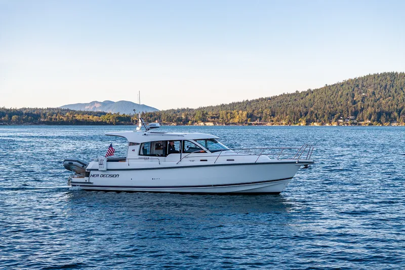 Slide: The Image of 2024 Nimbus 365 Coupe cruising on a scenic lake with forested hills in the background. - 35